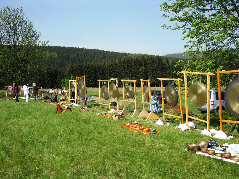 Gongs und Klangschalen im Freien auf einer Wiese aufgebaut