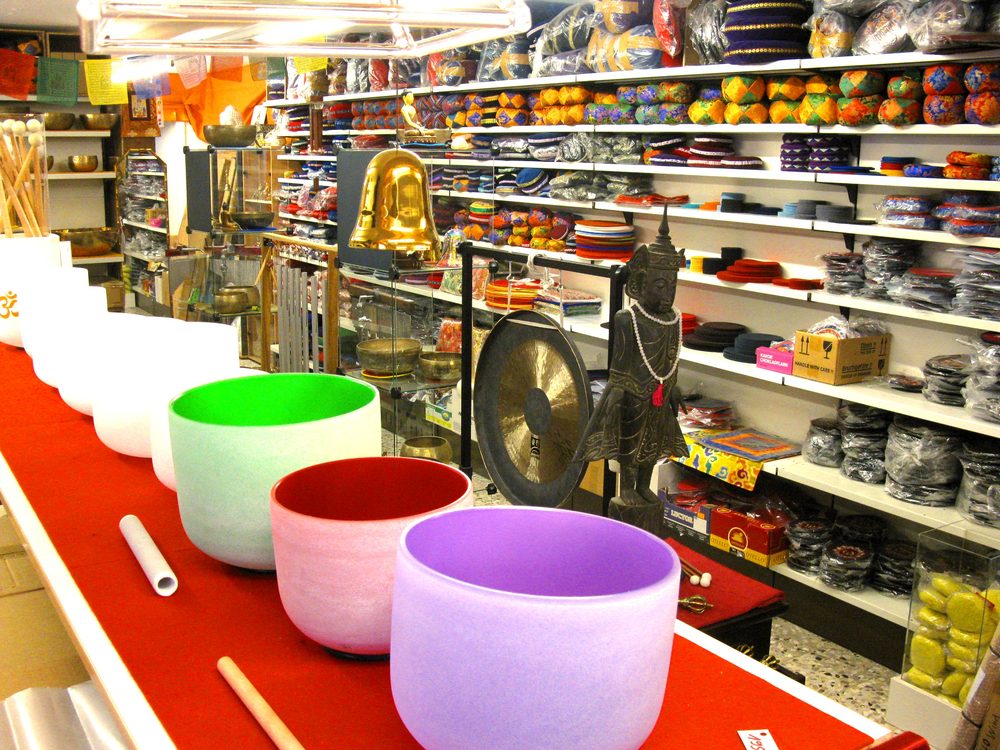 Farbige Kristallklangschalen auf einem roten Tisch im Showroom
