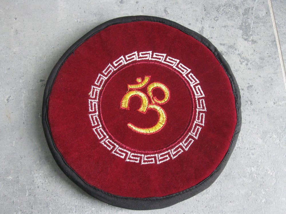 Rotes Rundkissen mit goldener Om-Stickerei