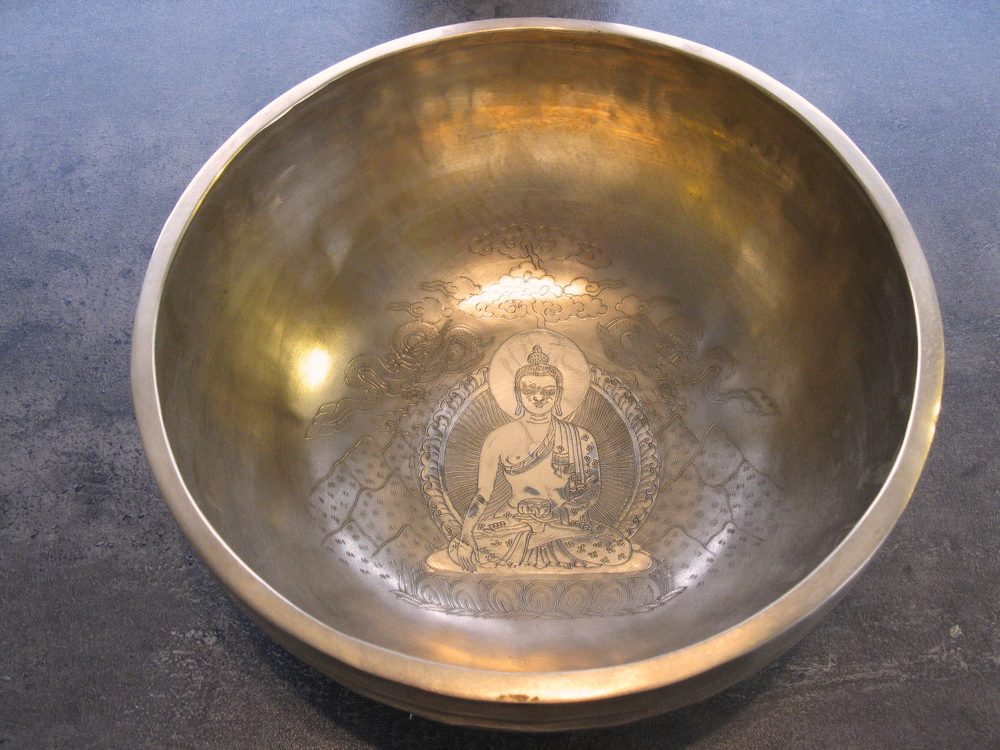 Innenansicht einer Klangschale mit graviertem Buddha-Motiv