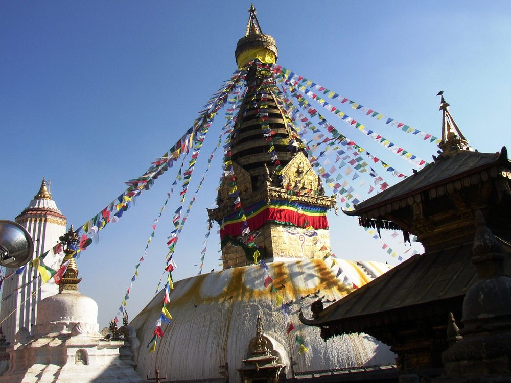 Stupa in Nepal mit Gebetsfahnen und vergoldeter Turmspitze